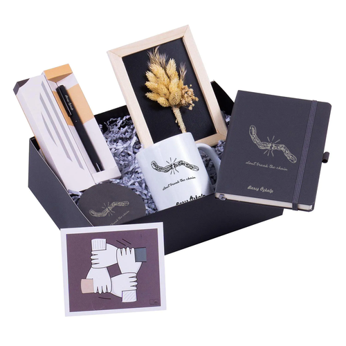 Coffret cadeau entreprise fin d'année ouvert : agenda, mug et sous-verre au nom, stylo, cadre de fleurs séchées et carte