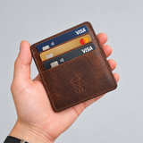 Porte-carte en cuir vieilli – marron, tenu en main